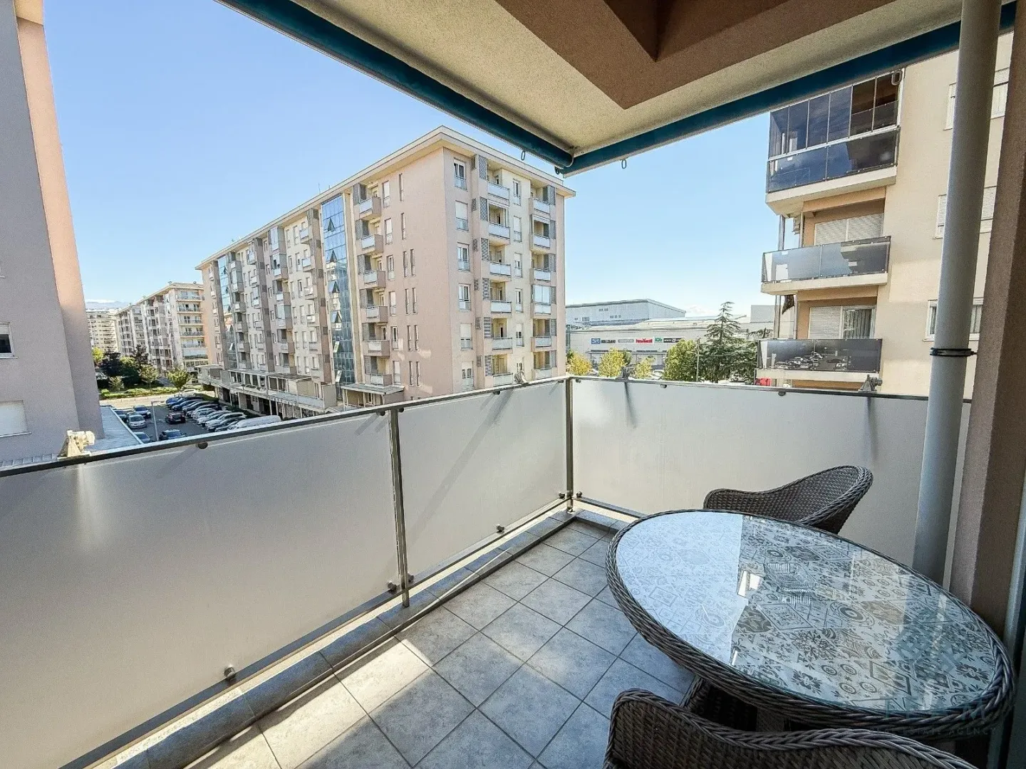 Furnished balcony with a table and chairs and a city view.