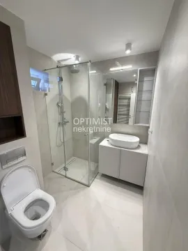 Modern bathroom equipped with a shower cabin, washbasin, and toilet. - image 19