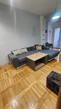 Dnevna soba sa ugaonom garniturom, stočićem i drvenim parketom. - image 3
