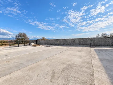 Concrete courtyard enclosed by a wall and gate. - image 11