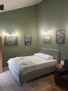 Spavaća soba sa bračnim krevetom, zelenim zidovima i umjetničkim slikama. - image 11