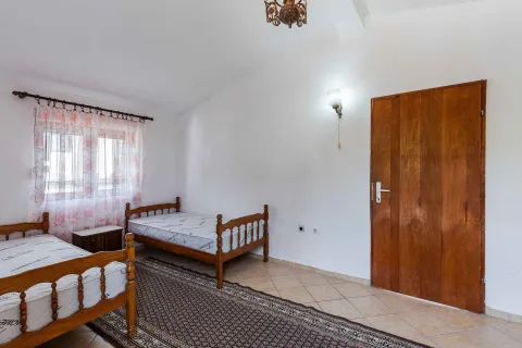 Spavaća soba sa dva drvena kreveta, prozorom i vratima. - image 11