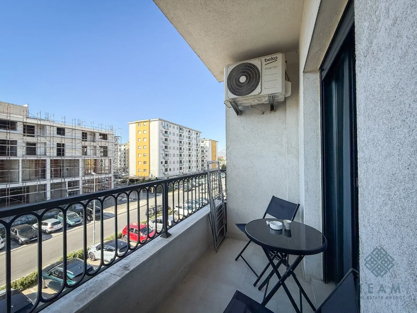 Furnished balcony with outdoor seating and an air conditioning unit.