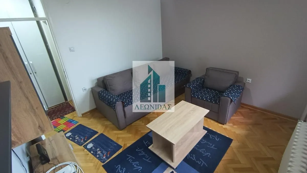 Living room with a sofa set, an armchair, a coffee table, and parquet flooring.