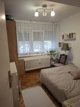 Furnished bedroom with a bed, window, and wooden flooring. - image 10