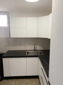 Manja kuhinja sa bijelim elementima i tamnom radnom pločom. - image 6