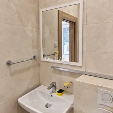 Bathroom with a washbasin, mirror and beige tiles. - image 3
