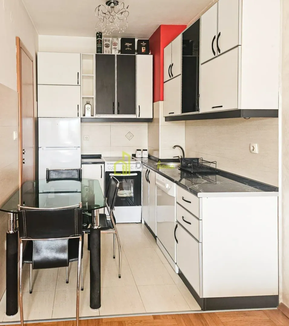 Small kitchen with white cabinets, dining table and glass top.
