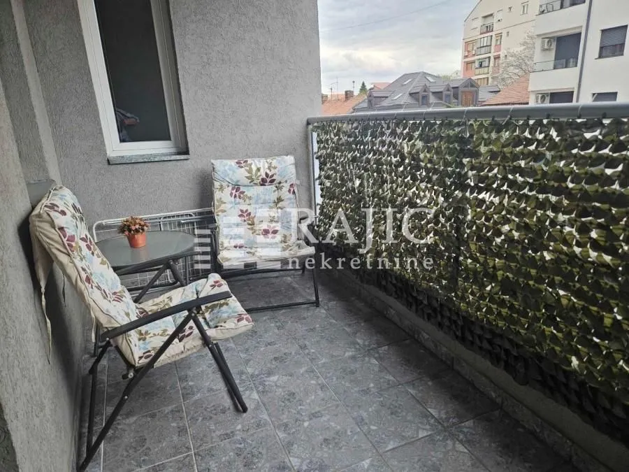 Small furnished balcony with chairs and a small table.