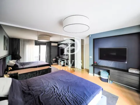 Spacious bedroom with a double bed, mirrored wardrobe, and a wall-mounted TV. - image 11