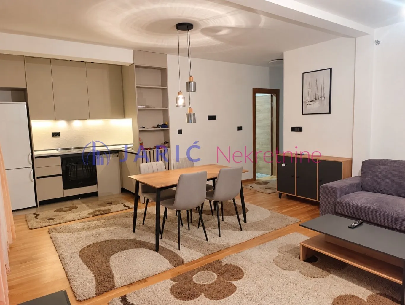 Living room with dining area and kitchen in an open space.