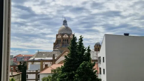 Pogled sa prozora na gradski pejzaž i okolne krovove. - image 9