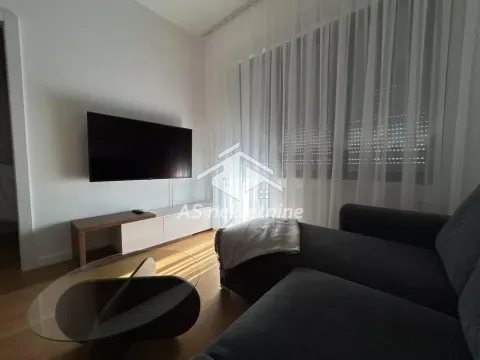 Living room with a corner sofa, wall-mounted TV, and a large window with curtains. - image 3