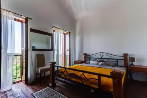 Spacious bedroom with a double bed and balcony access. - image 9