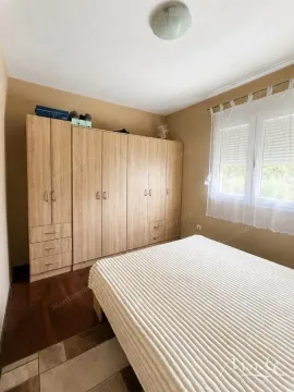 Spavaća soba sa bračnim krevetom i velikim drvenim ormarom. - image 8