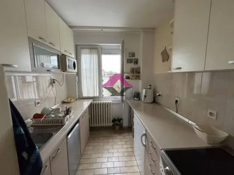 Manja uska kuhinja sa belim elementima i prozorom na kraju prostorije. - image 6