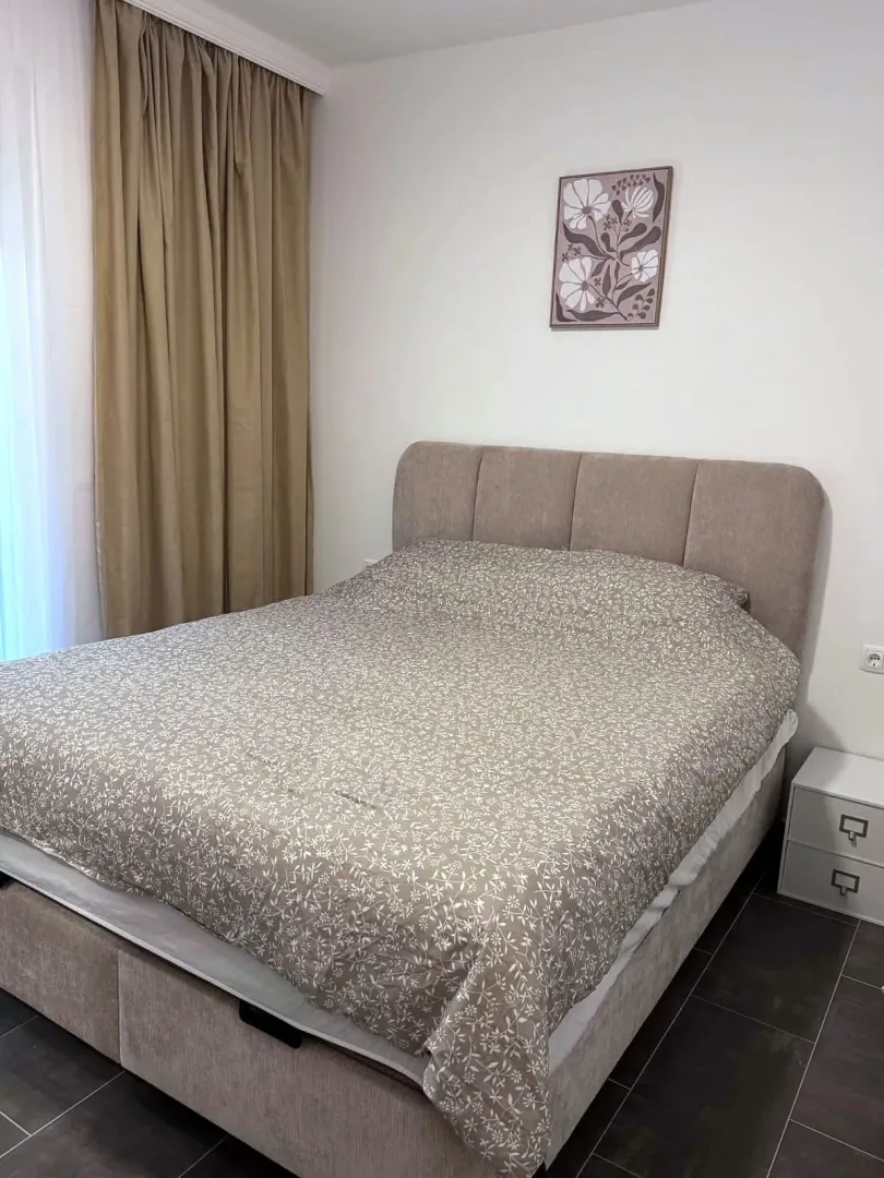 Bedroom with a double bed, bedside table, and curtains.
