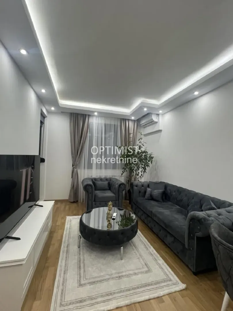Modern living room with a sofa set, coffee table, and TV unit.