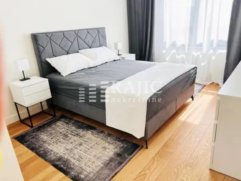 Modern bedroom with a double bed, bedside tables and wooden flooring. - image 6