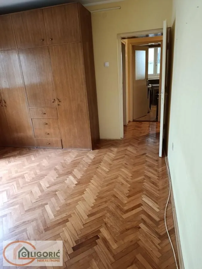 Bedroom with a large built-in wardrobe and parquet flooring.