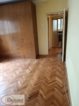 Bedroom with a large built-in wardrobe and parquet flooring. - image 2