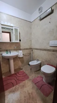 Kupatilo opremljeno umivaonikom, šoljom, bideom i ormarićem sa ogledalom. - image 7