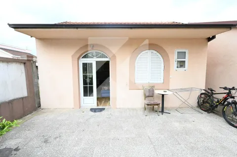View of the exterior of the house with an entrance door and paved courtyard. - image 6