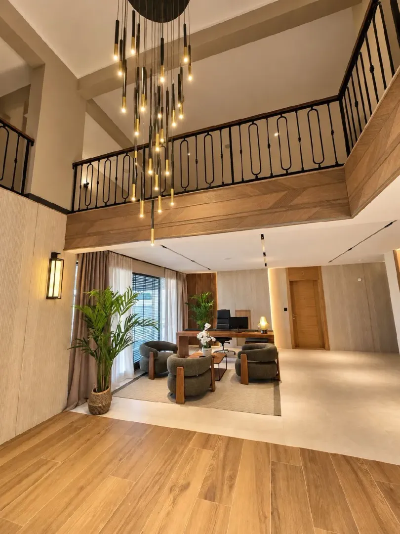 Spacious bright living room with a gallery and a modern chandelier.