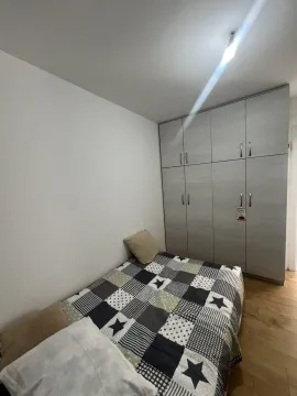 A simply furnished bedroom featuring a bed and a large built-in wardrobe. - image 8