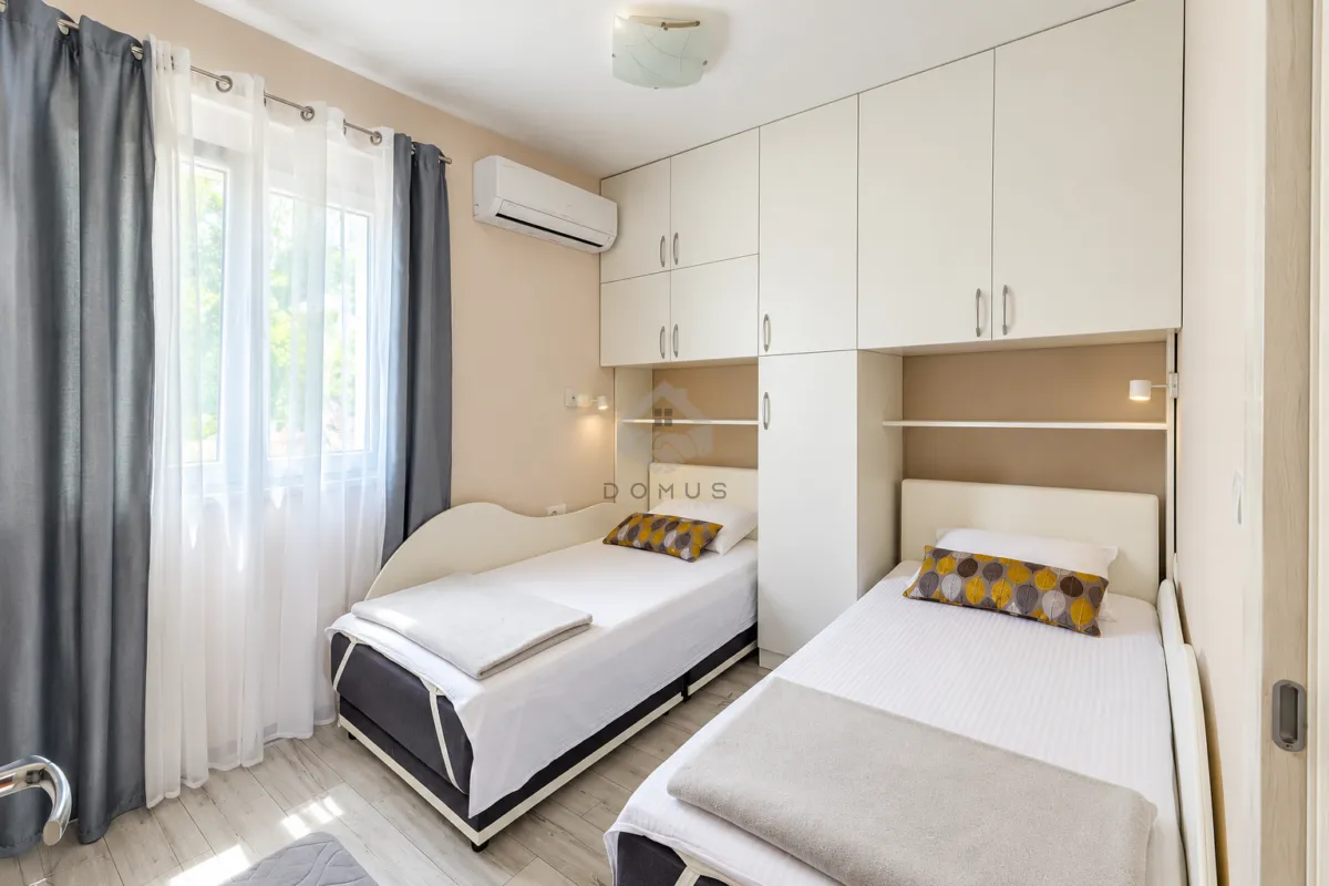 Bedroom with two single beds and fitted wardrobes.
