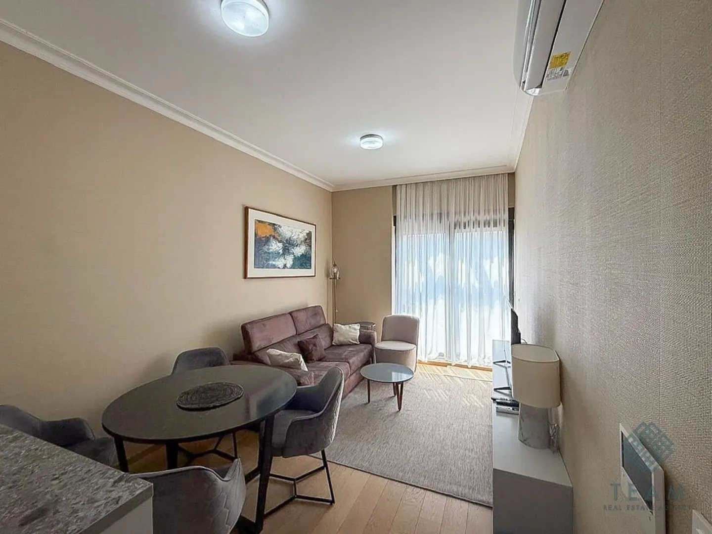 Living room with a sofa set, dining table, and access to the terrace.