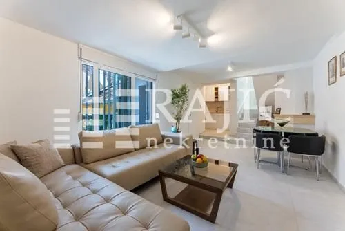 Living room with a sofa and dining area in an open-plan space.
