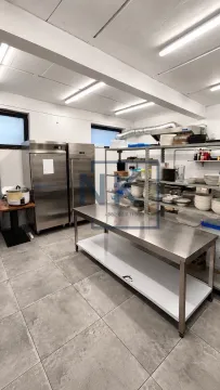 Commercial kitchen with stainless steel work tables and shelving. - image 13