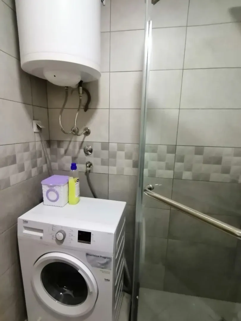 Bathroom with washing machine and shower.