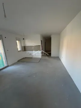 Prazna prostorija u izgradnji sa belim zidovima i podom u košuljici. - image 2