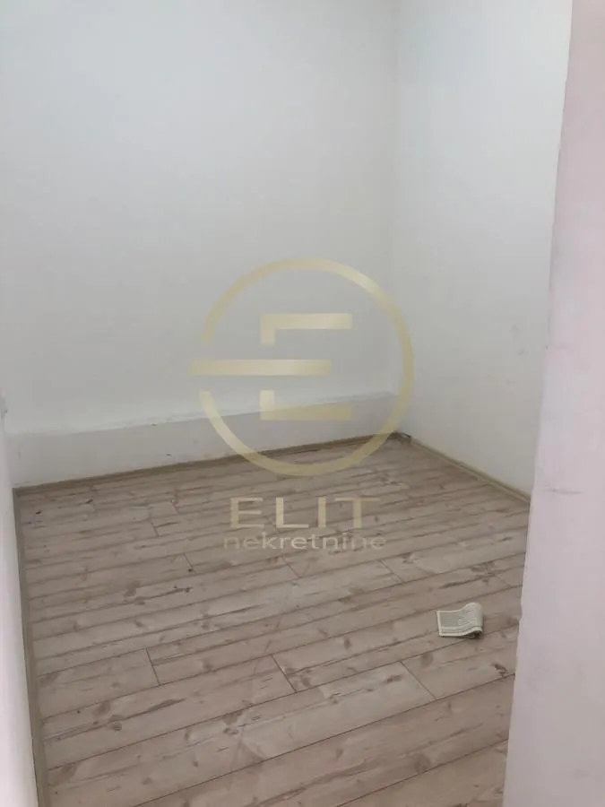 Empty unfurnished room with white walls and wooden flooring.