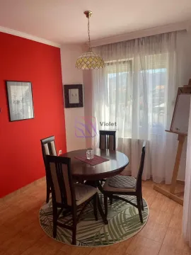 Dining table with chairs in a living room with a red wall. - image 7
