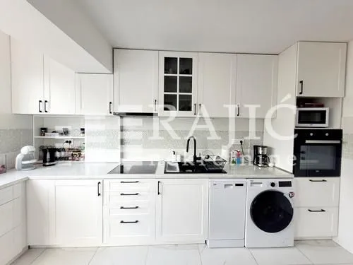 Modern white kitchen with built-in appliances.
