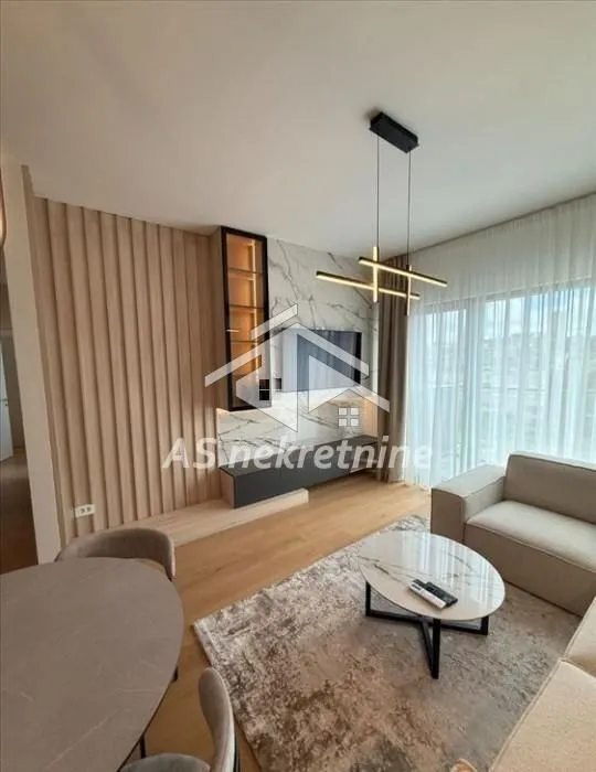 Living room with sofa, TV unit, and dining table.