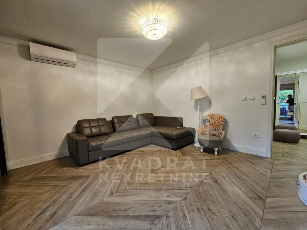 Dnevni boravak sa ugaonom garniturom i klima uređajem.