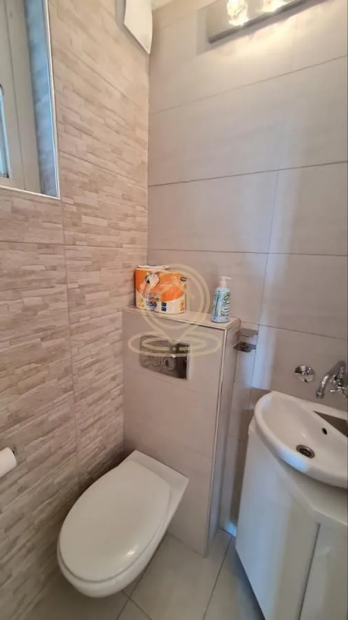 Manje kupatilo sa WC šoljom, ugradnim vodokotlićem i umivaonikom.
