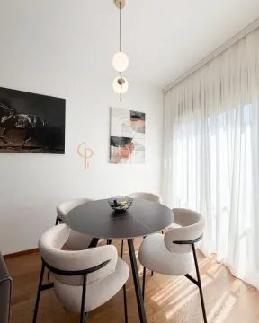 Trpezarija sa okruglim stolom i modernim stolicama pored prozora. - image 4