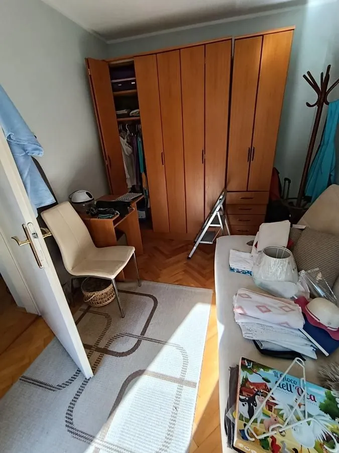 Manja soba sa velikim drvenim garderoberom, krevetom i radnim stolom.