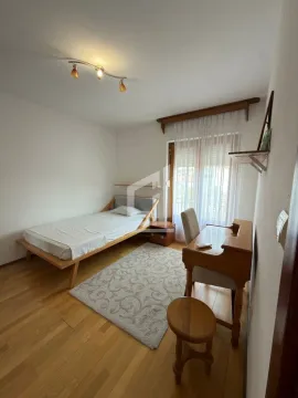 Bedroom with a single bed, desk, and hardwood flooring. - image 11