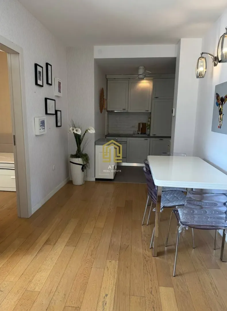 Dining area with a view of the kitchen in a furnished interior.
