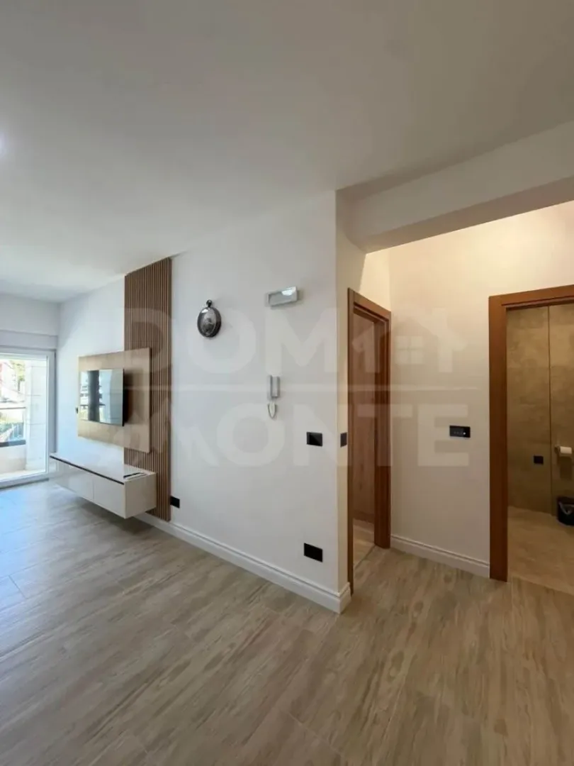 Living room with wooden wall panels and a TV.