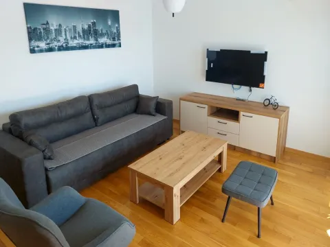 Dnevna soba sa garniturom za sjedenje, drvenim stočićem i televizorom. - image 7