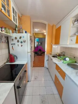 Manja kuhinja sa belim i narandžastim elementima i šporetom. - image 12