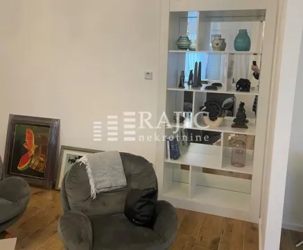 Living room with an armchair and a white bookcase. - image 8