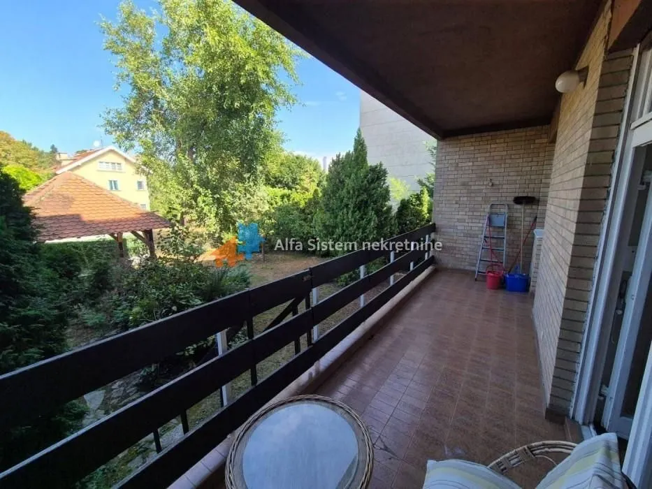 Spacious covered terrace with a view of the yard and greenery.